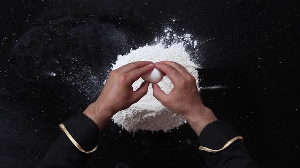 Raw Egg Falls on a Pile of Flour on a Black Background Slowmotion Shooting