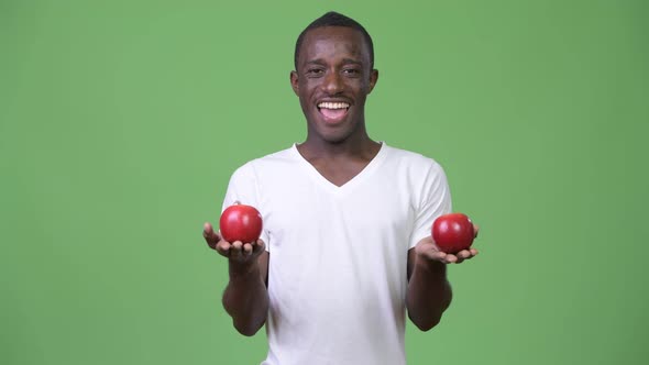 Young Happy African Man Smiling with Red Apples