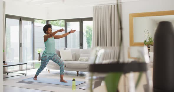 Happy african american wearing sportswear, exercising, using laptop