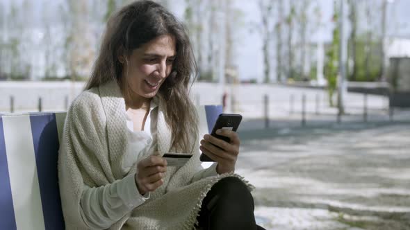 Smiling Middle Aged Woman Typing Card Number on Smartphone