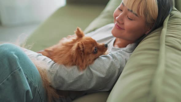 Positive Asian woman petting her dog