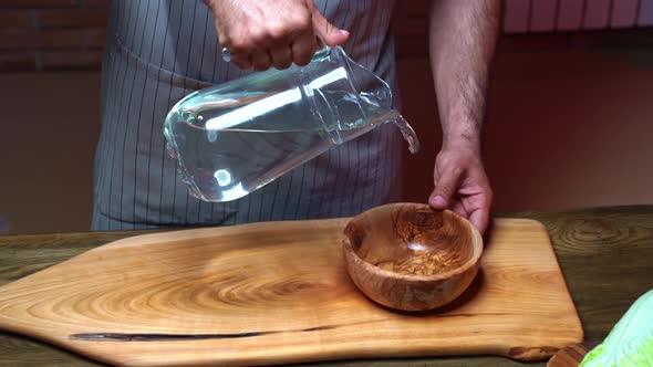 in a Wooden Bowl Pour Water From a Glass Carafe