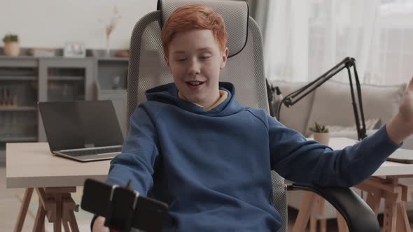 Red-haired Boy Filming Vlog on Smartphone