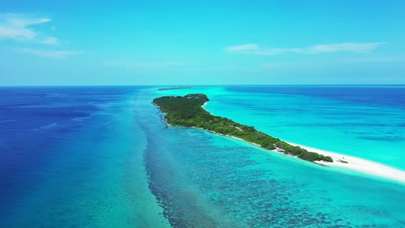 Beautiful overhead island view of a white sandy paradise beach and blue ocean background in vibrant 