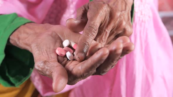 Close Up of Pills and Capsule on Senior Women's Hand