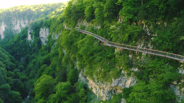 Aerial Shot of an Awesome Nature  High Cliffs with Bright Green Vegetation and a Hiking Trail on It