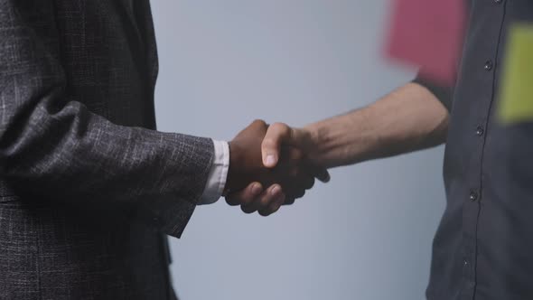 Closeup Shaking Hands of Unrecognizable African American and Middle Eastern Partners in Office