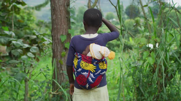 African girl carrying a baby