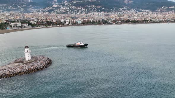 Ship tug sails out of port aerial view 4 K