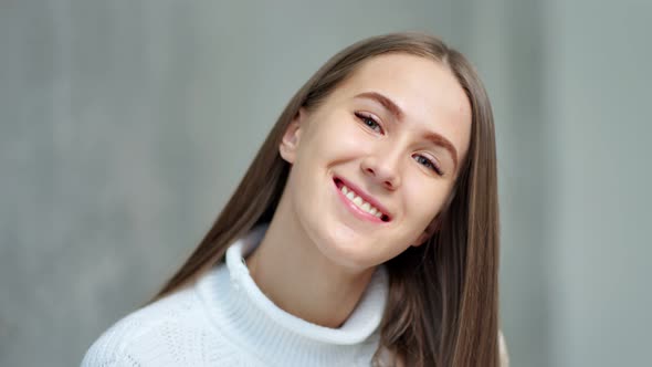 Closeup Portrait of Charming Young European Woman Smiling Posing in Studio at Gray Background