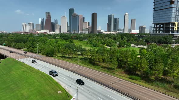 Buffalo Bayou Park and Houston Skyline. American and Texas flags wave in breeze. Rising aerial pedes