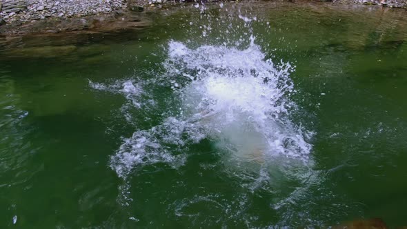 Happy Healthy Caucasian Woman Jumping in Mountain River During Summer Leisure Activity