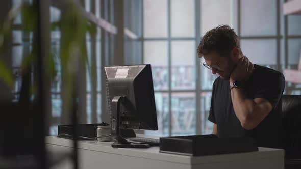 Tired Businessman Having Neck Pain in Office