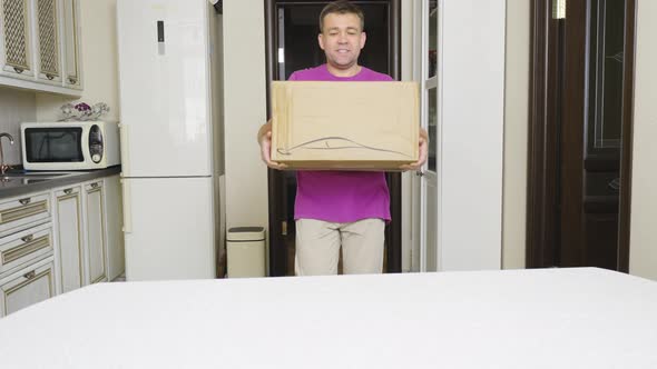 a Man Brings in Puts and Opens a Box with an Electric Car Charger