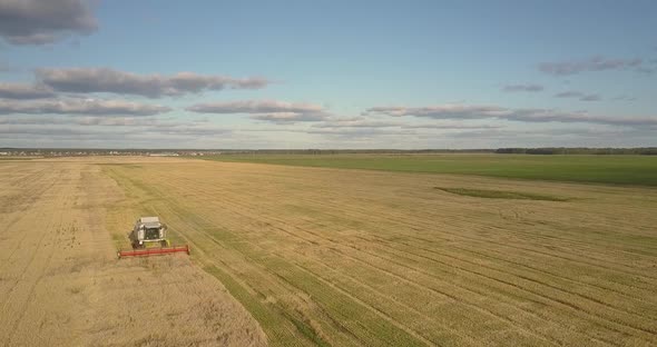 Aerial Landscape with Gold Field and Operating Harvester