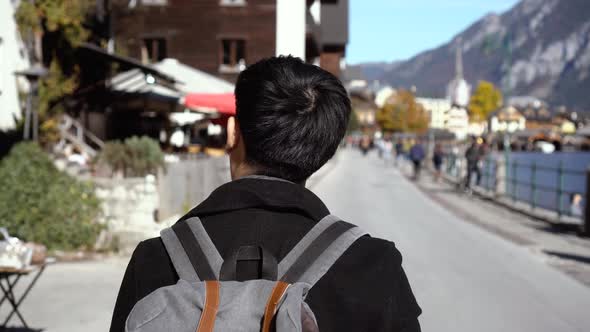 Young Asian Male Tourist Shopping and Looking at Souvenirs in Hallstatt Lake During Trip to Austria