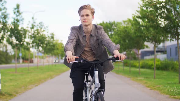 Young Man Riding Bicycle on City Street