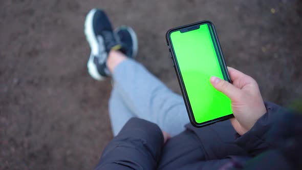 Womans Hand Holding Modern Smartphone, Touching Green Screen