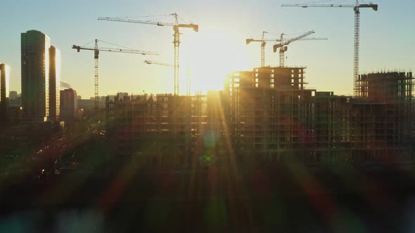 Several Construction Tower Cranes in the Process of Building Houses in a New Residential Complex at