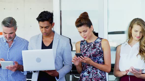 Executive using mobile phone, digital tablet and laptop in office 4k