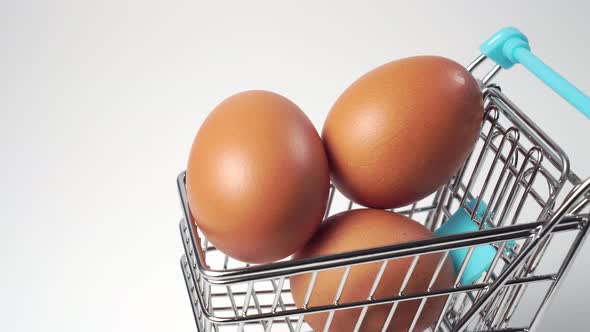 Miniature shopping cart with fresh chicken farm eggs