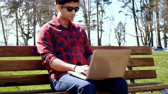 Man using laptop in the park 4k