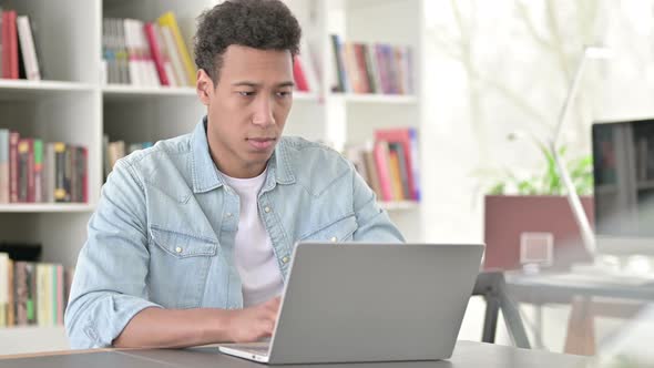 Young African American Man with Neck Pain Working on Laptop 