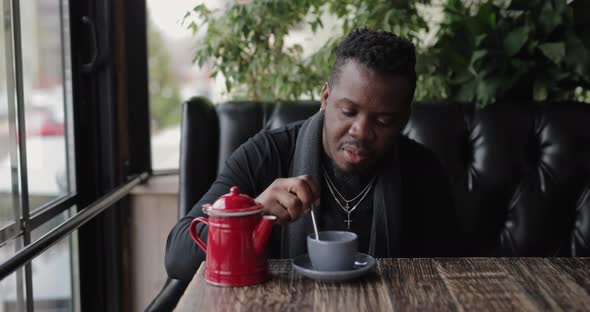 African American Man Mixing Sugar in a Tea Cup