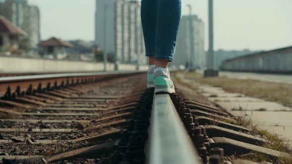 Woman Feet In Jeans Walking On Rail Road When Train Or Tram Cancelled. Legs Walking On Railway.