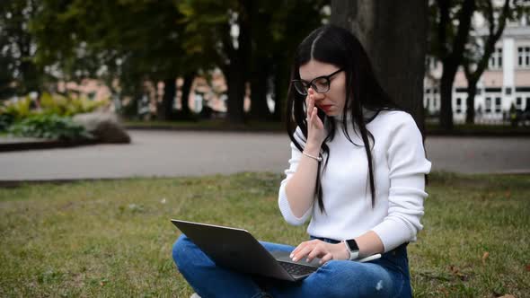 Pretty Woman Working on Laptop Computer on Green Lawn