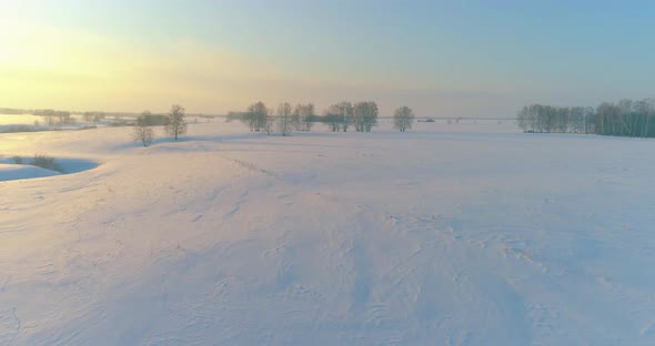 Aerial View of Cold Arctic Field Landscape Trees with Frost Snow Ice River and Sun Rays Over Horizon