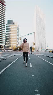 Carefree Woman Walking Along Street in Downtown