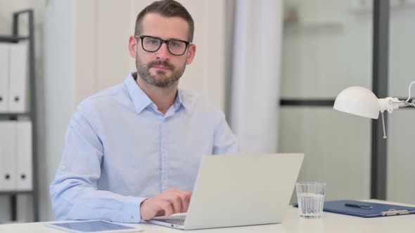 Thumbs Down Sign By Middle Aged Man with Laptop