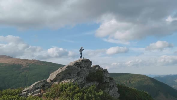 Happy Man at Top of Mountain Celebrates Climb to Peak By Jumping Dancing