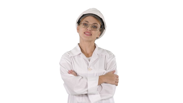 Professional woman in lab coat and white hardhat walking