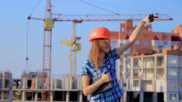 Young female engineer on the radio coordinates the progress