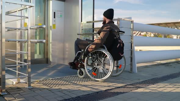 Paraplegic Man in Manual Wheelchair is Using Lift for Disabled People in City