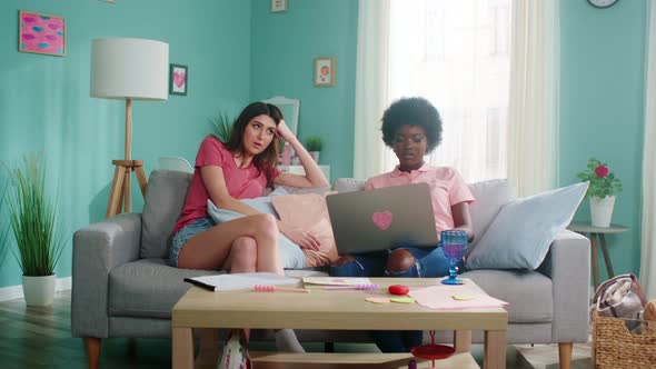 Young Women Sit On Sofa and Communicate