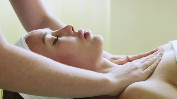 Young Woman Enjoys Facial Massage in Beauty Spa Salon on Wellness Treatment