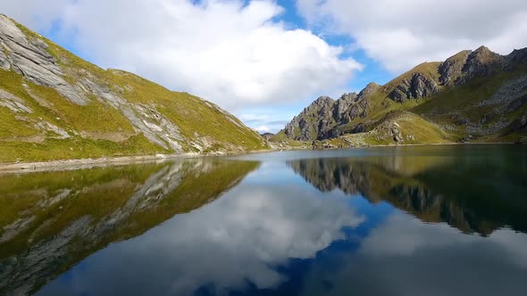 Perfect reflection flying over mountain lake (Lac des Vaux, Verbier)