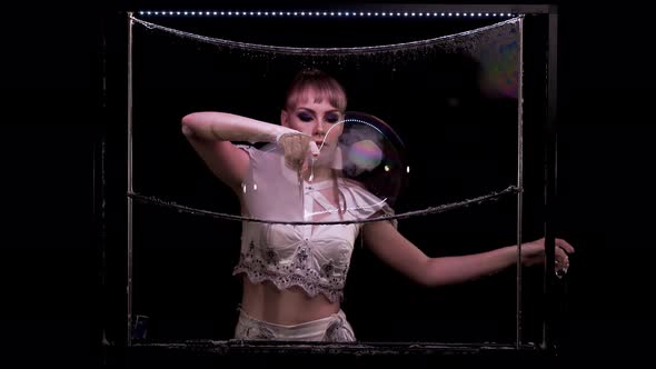 Pretty Girl Does Tricks with Soap Bubbles. She Plays with Bubbles, Pierces, Releases Smoke. With