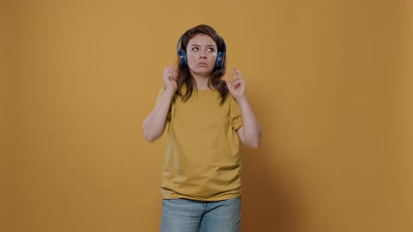 Portrait of Casual Woman with Wireless Headphones Listening to Upbeat Music and Dancing Alone