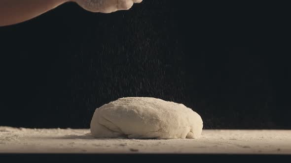 Male Hands Sprinkle a Piece of Baking Dough with Flour
