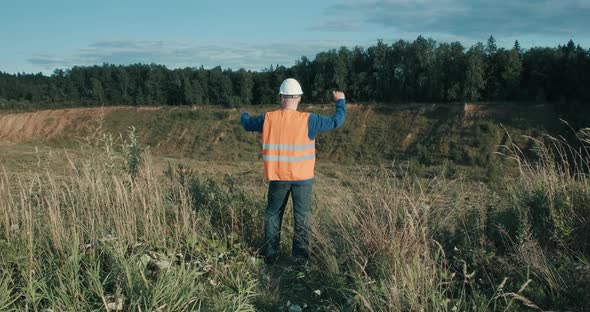 Working Engineer in Helmet Next to Sand Pit