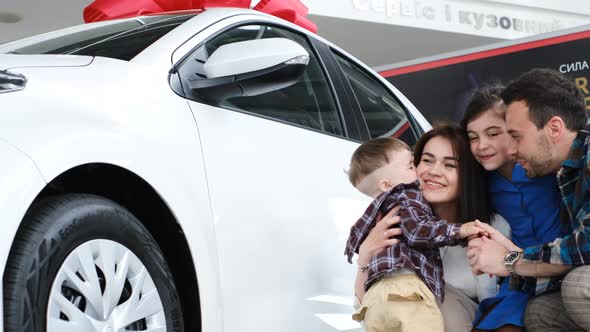 Happy Family with Children Bought a New Car They Hug Rejoice and Laugh