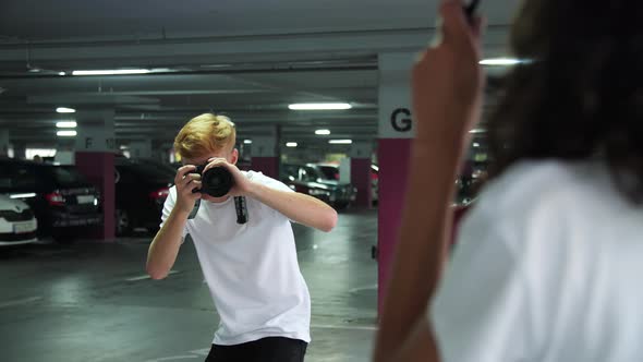 Man With Camera Taking Photos Of Woman At Parking Lot