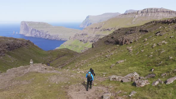 Panoramic Drone Shot of Steep Cliff View in Faroe Islands and Two Hikers