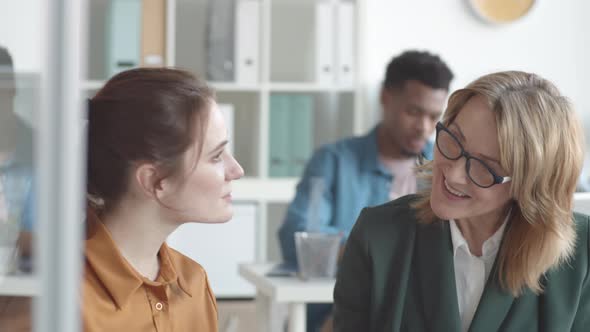 Caucasian Female Mentor Training New Employee in Office