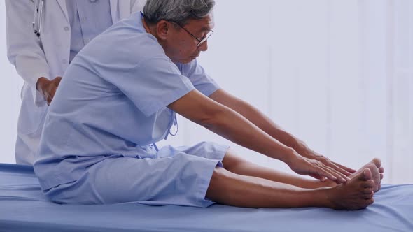 Doctor examining back of elderly patient in clinic