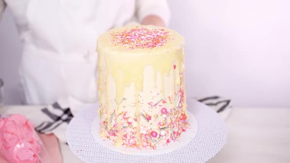 Step by step. Dripping a white chocolate ganache on birthday cake with white buttercream icing.
